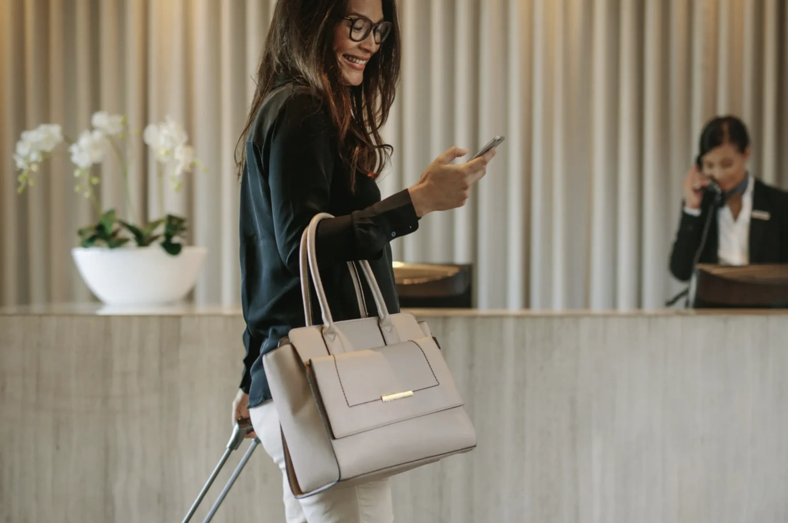 Hotel guest using a smartphone with strong cell signal in a warmly lit lobby