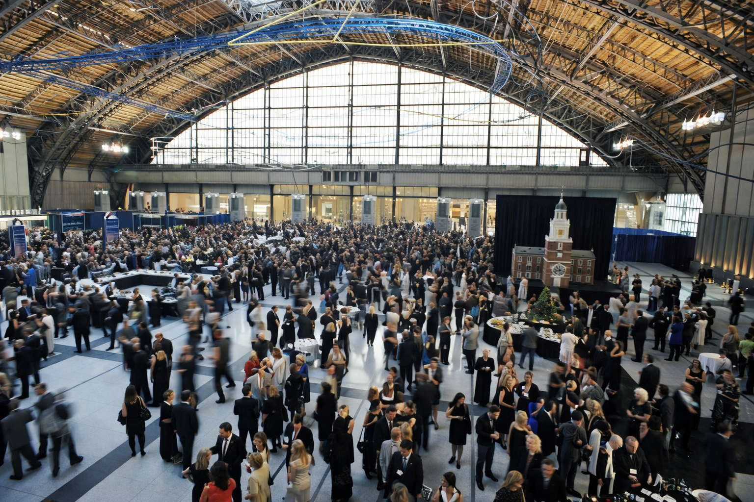 Attendee using a phone in a bright convention center lobby with a softly busy registration area in the background