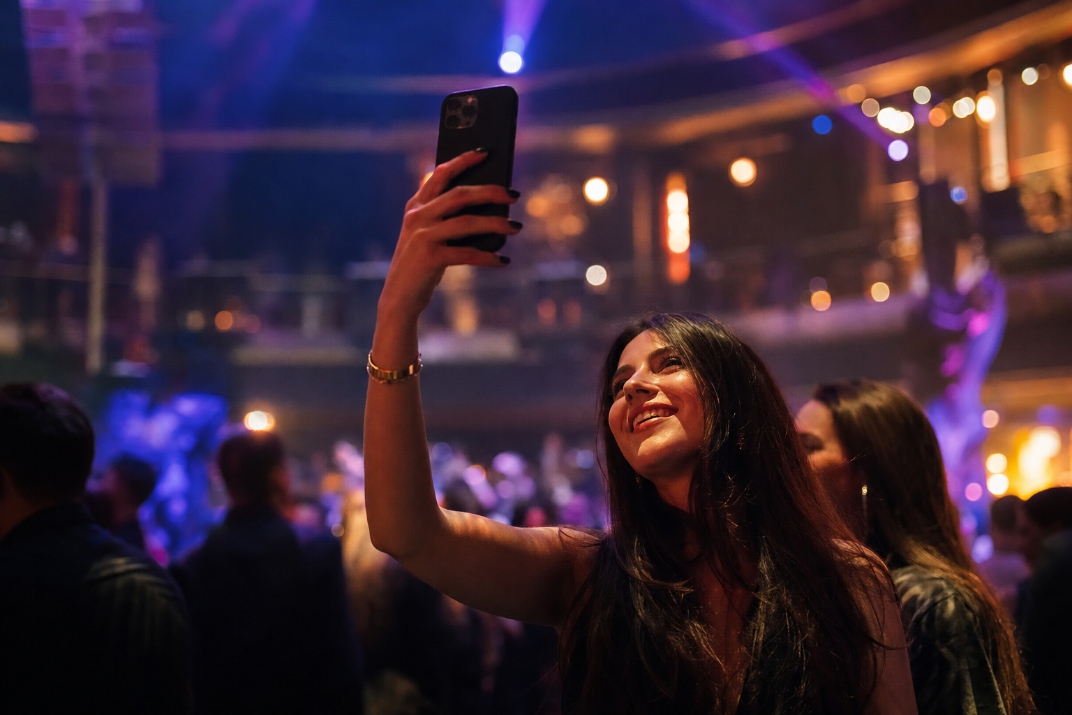Guests connected on their phones inside a busy nightclub with stage lights and a packed dance floor