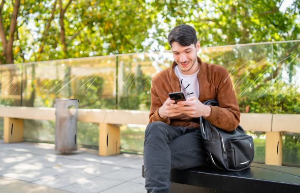 Man using his phone in an office park, highlighting LongFi Connect’s ability to enhance outdoor cellular coverage for businesses and public areas